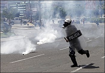 Riot police run through tear gas as their disperse a march of Honduras' ousted President Manuel Zelaya supporters who demanded his return to power in Tegucigalpa, Thursday, Oct. 29, 2009. Honduras' opposing political factions resumed talks Thursday and expressed hope that a deal could be reached soon to end the power crisis that has paralyzed the country since a coup four months ago. (AP Photo/Arnulfo Franco)